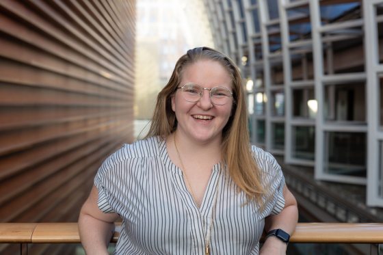 a person in a black and white stripped shirt smiling at the camera